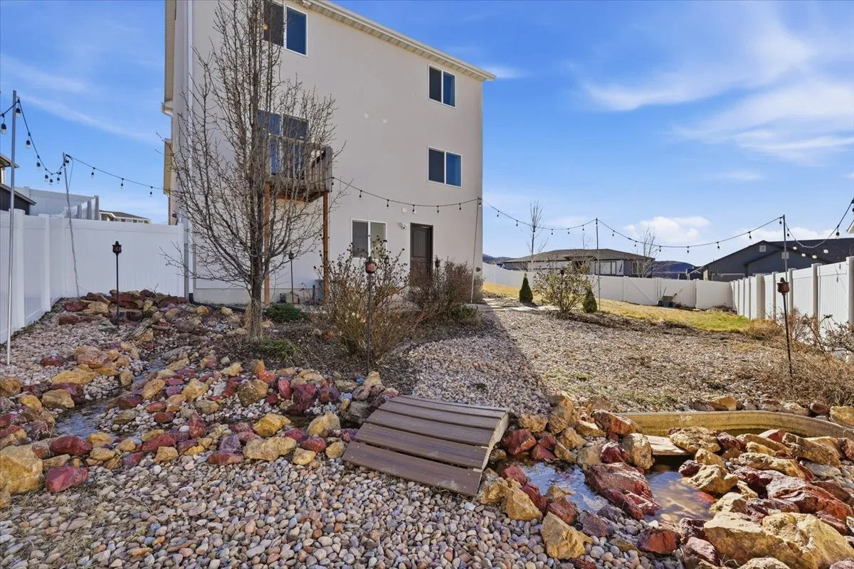 Rear view of property with a fenced backyard and stucco siding