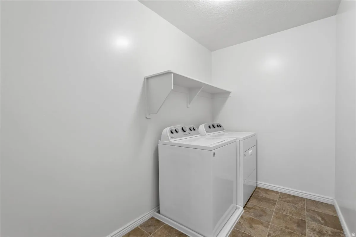 Laundry area with washing machine and clothes dryer and a textured ceiling