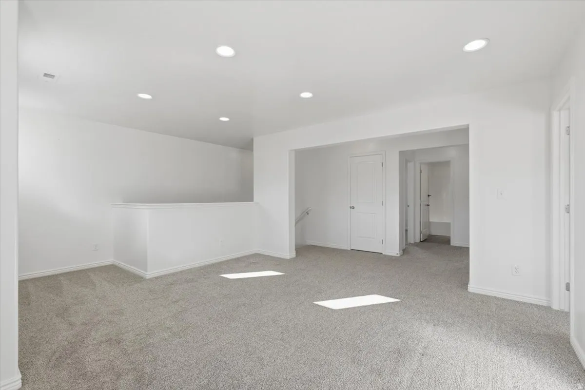 Spare room with light colored carpet and recessed lighting