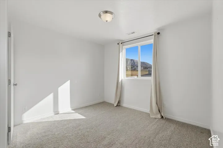 Empty room with light carpet and a mountain view