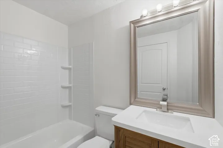 Full bath with vanity, bathing tub / shower combination, and a textured ceiling