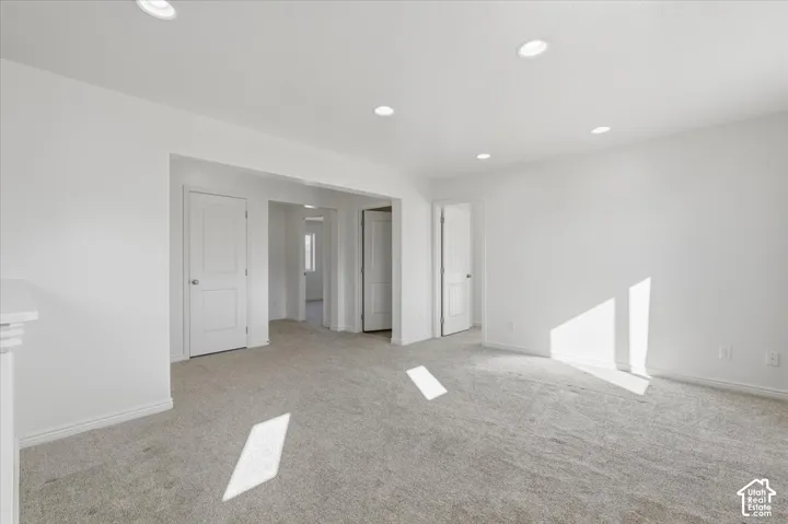 Empty room with recessed lighting and light colored carpet