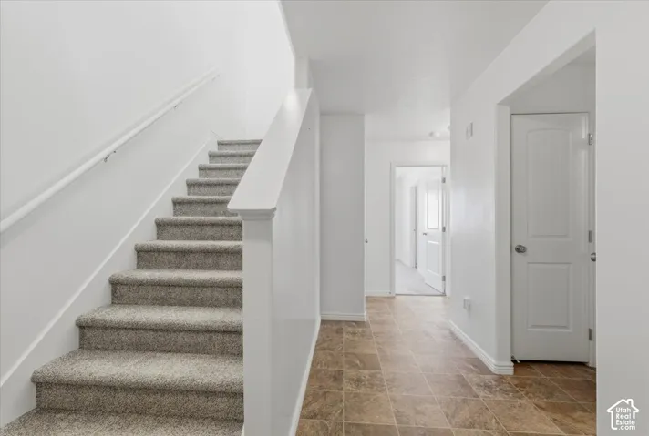Staircase with baseboards and stone finish floors