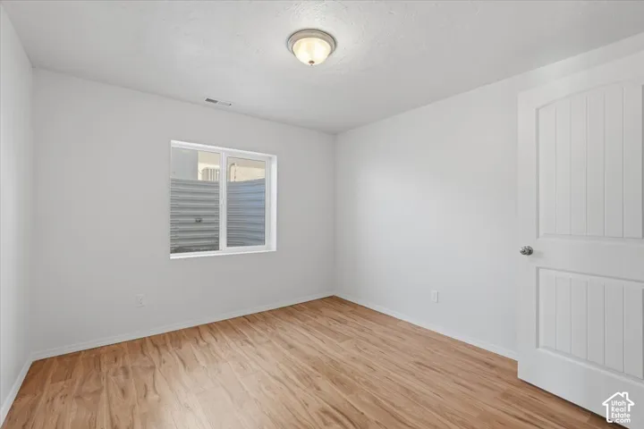 Empty room with light wood-type flooring and baseboards