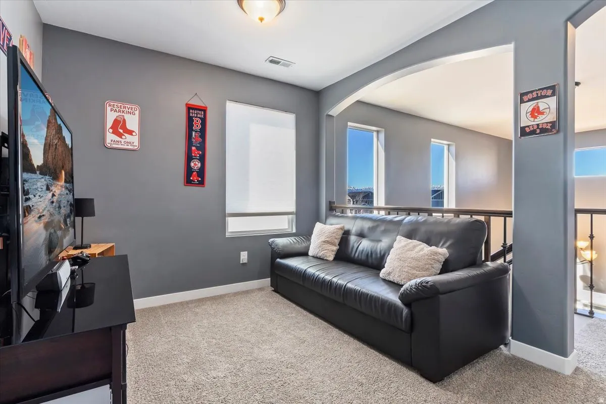 Living room with light colored carpet and arched walkways