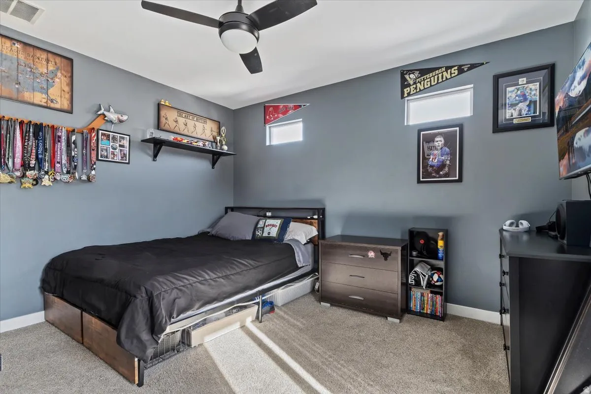 Bedroom featuring a ceiling fan and light carpet