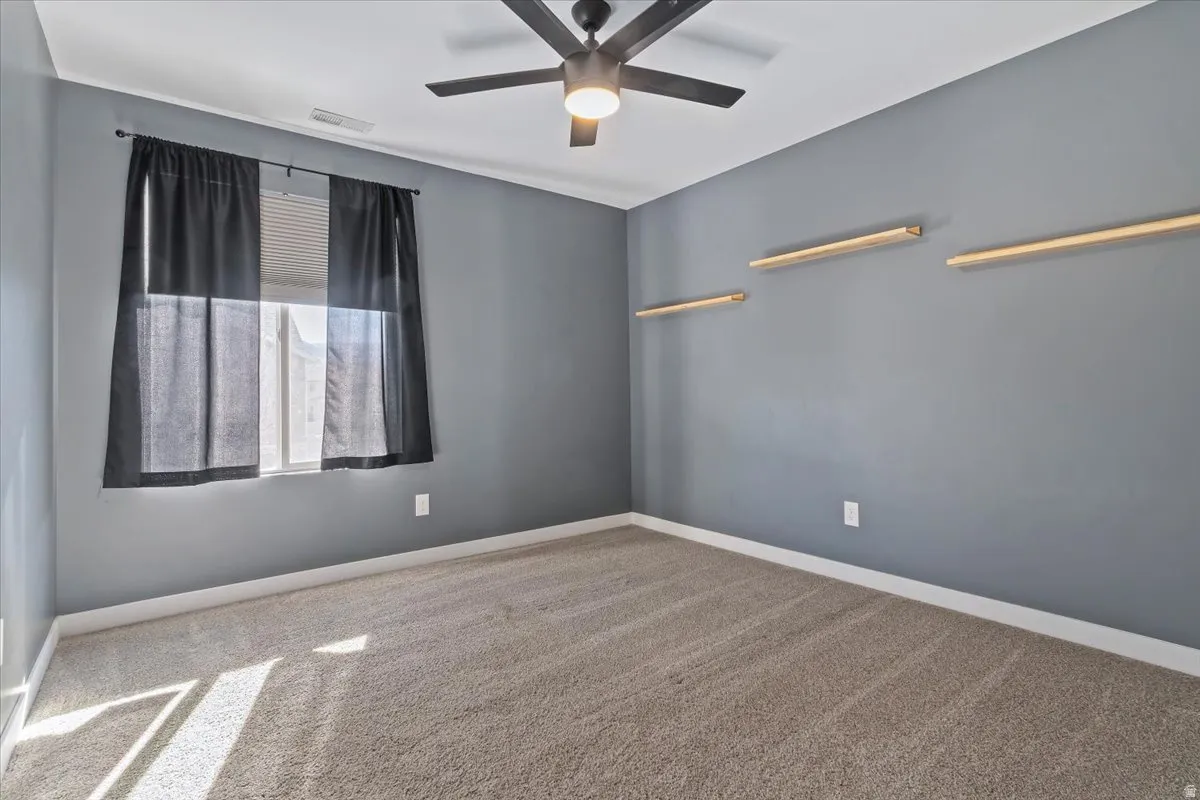Spare room with light colored carpet and ceiling fan