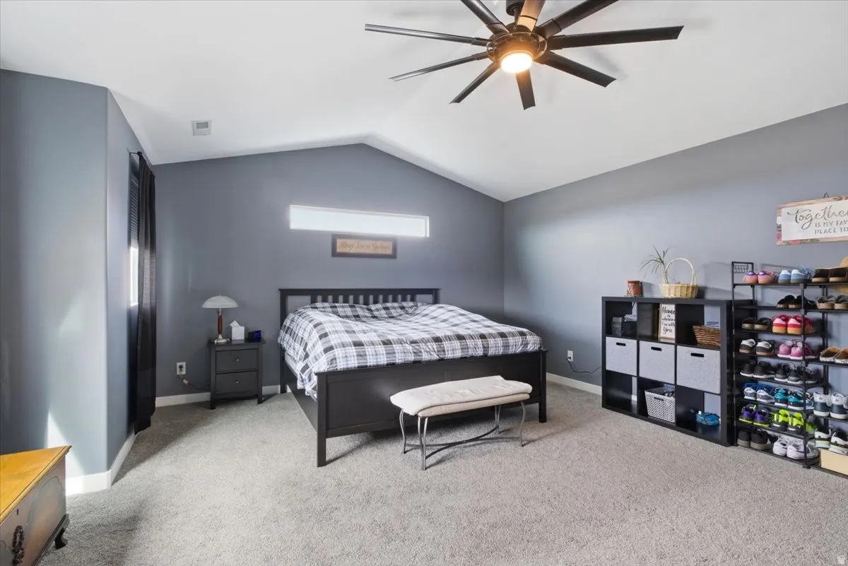 Bedroom featuring light carpet and a ceiling fan