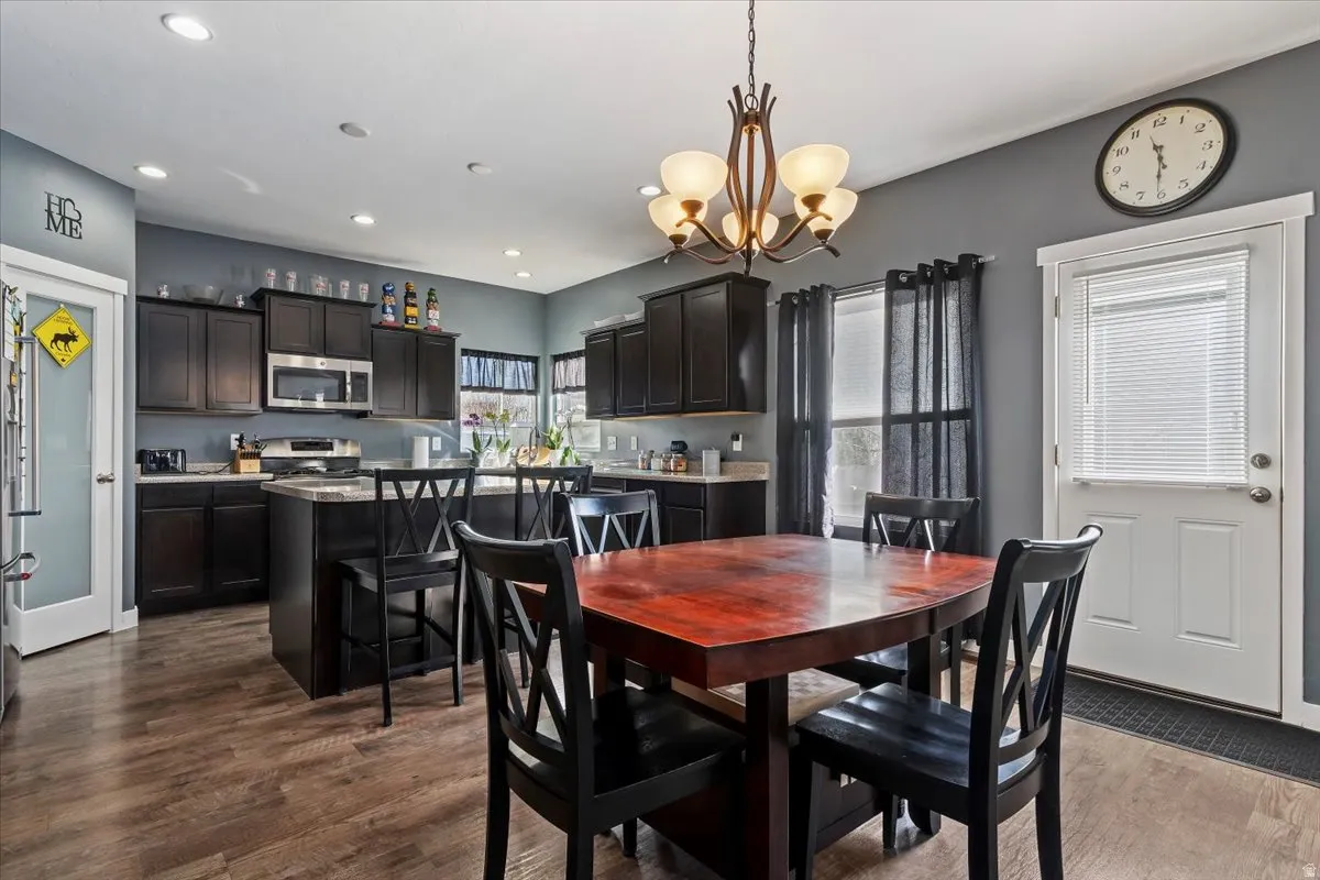 Dining space featuring dark wood-style flooring and hanging lights