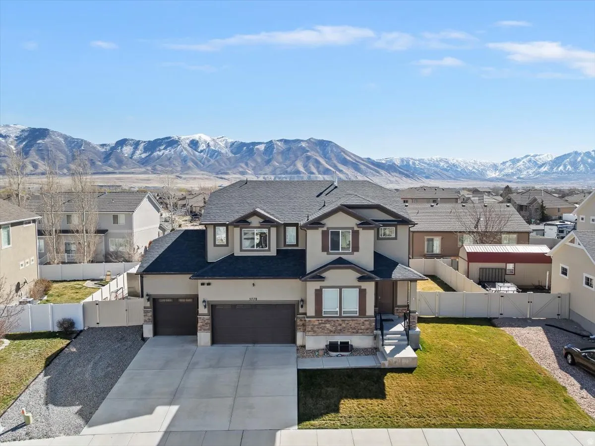 View of front of home featuring a gate, stucco siding, driveway, and a residential view