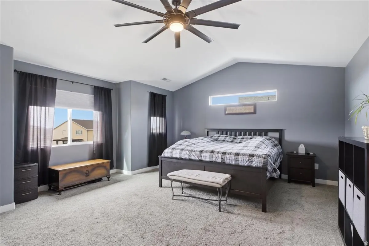 Bedroom with a ceiling fan and light colored carpet