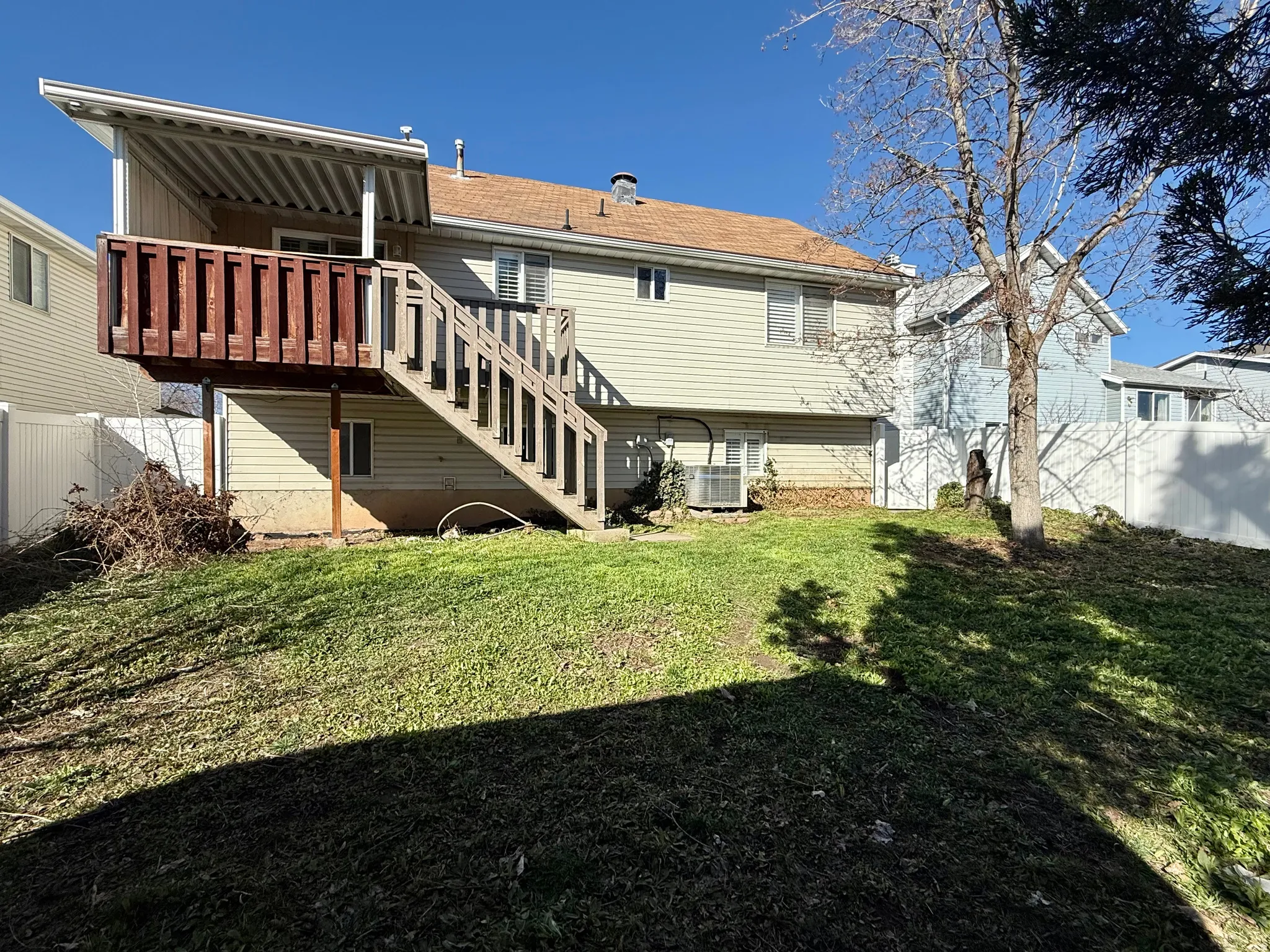 Rear view of property with stairs and a wooden deck
