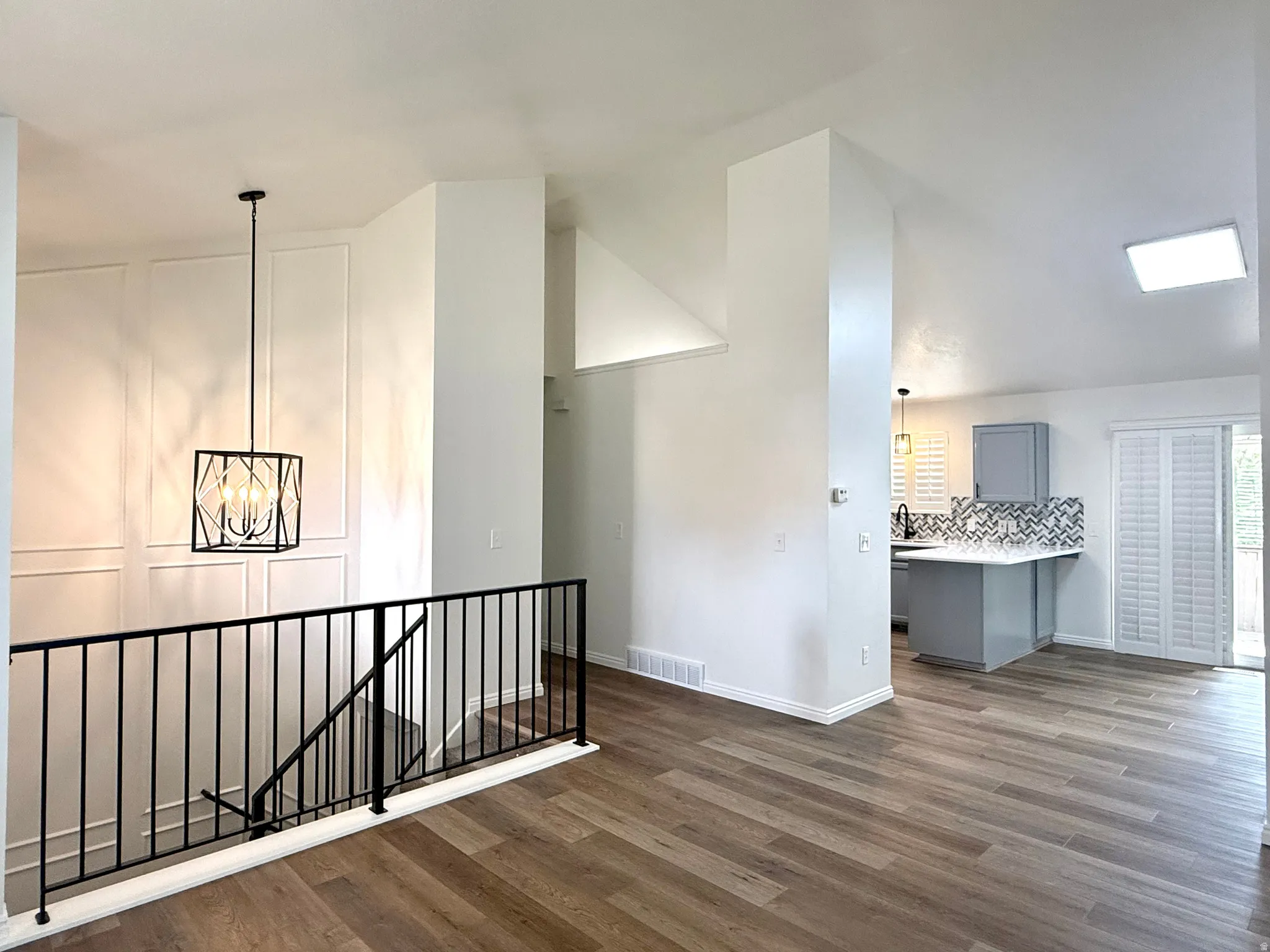 Hall featuring an upstairs landing, dark wood-style flooring, and a chandelier
