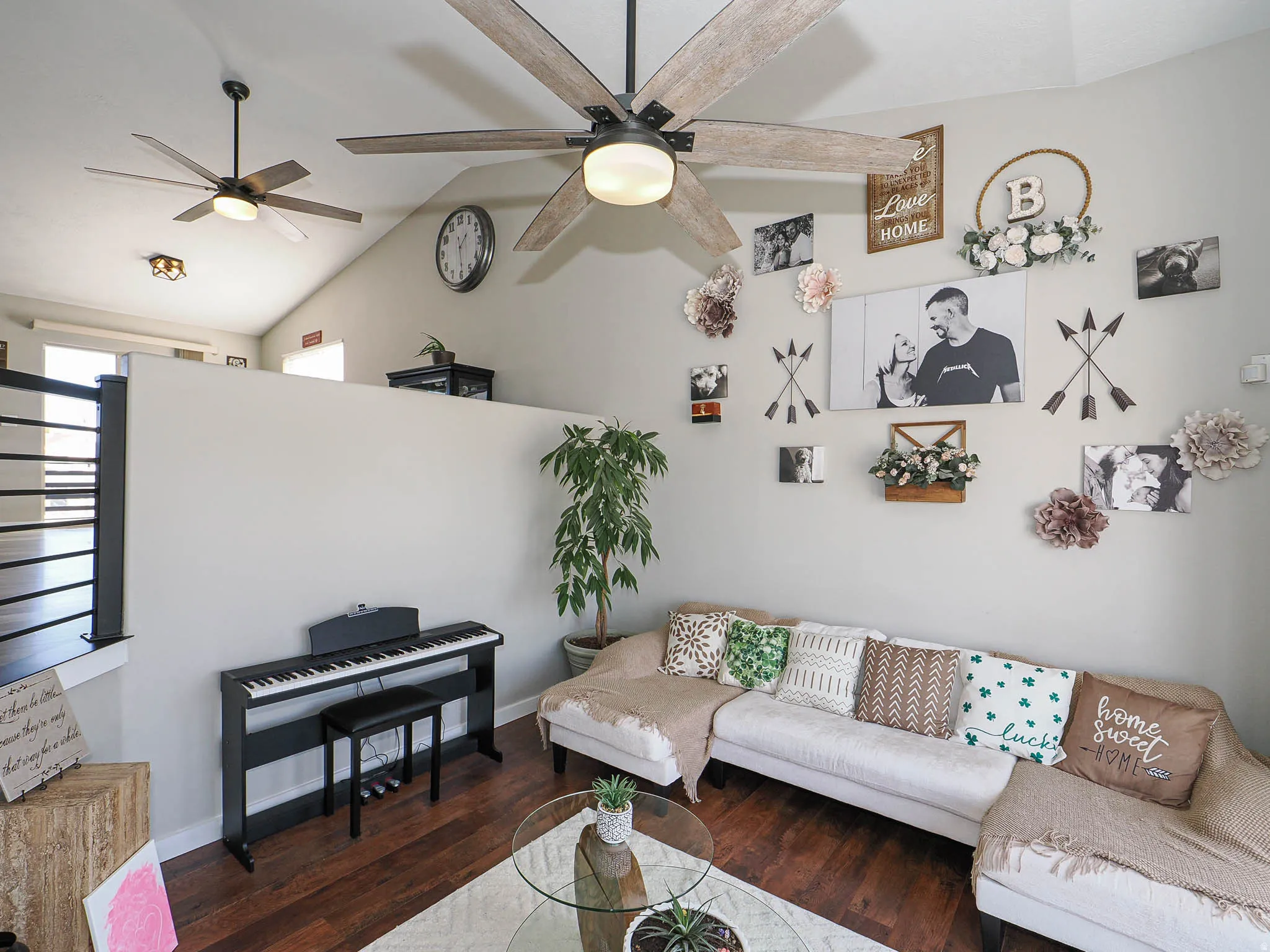 Living room featuring vaulted ceiling, dark wood-type flooring, and a ceiling fan