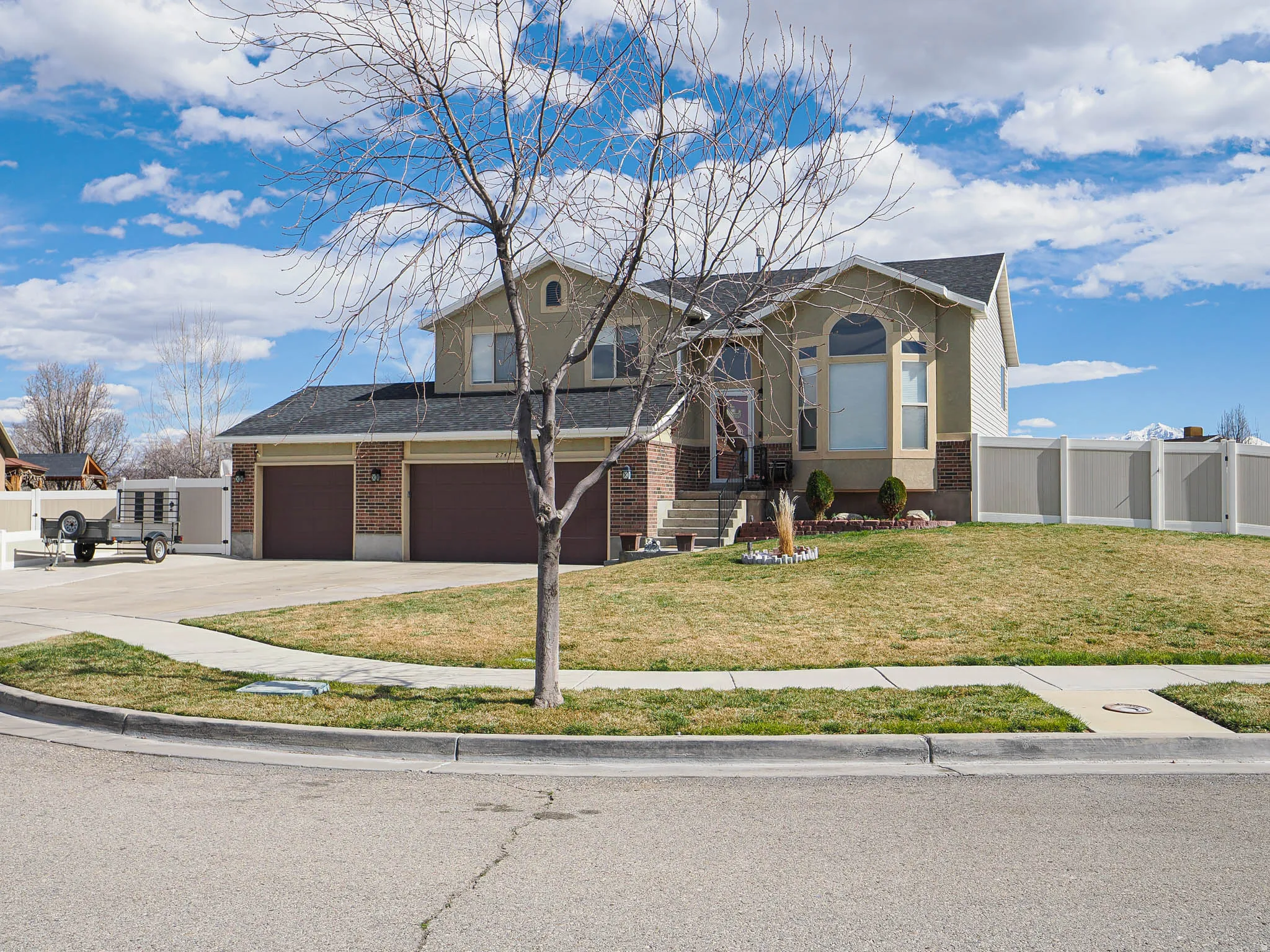 View of front of house with driveway, brick siding, roof with shingles, and a garage