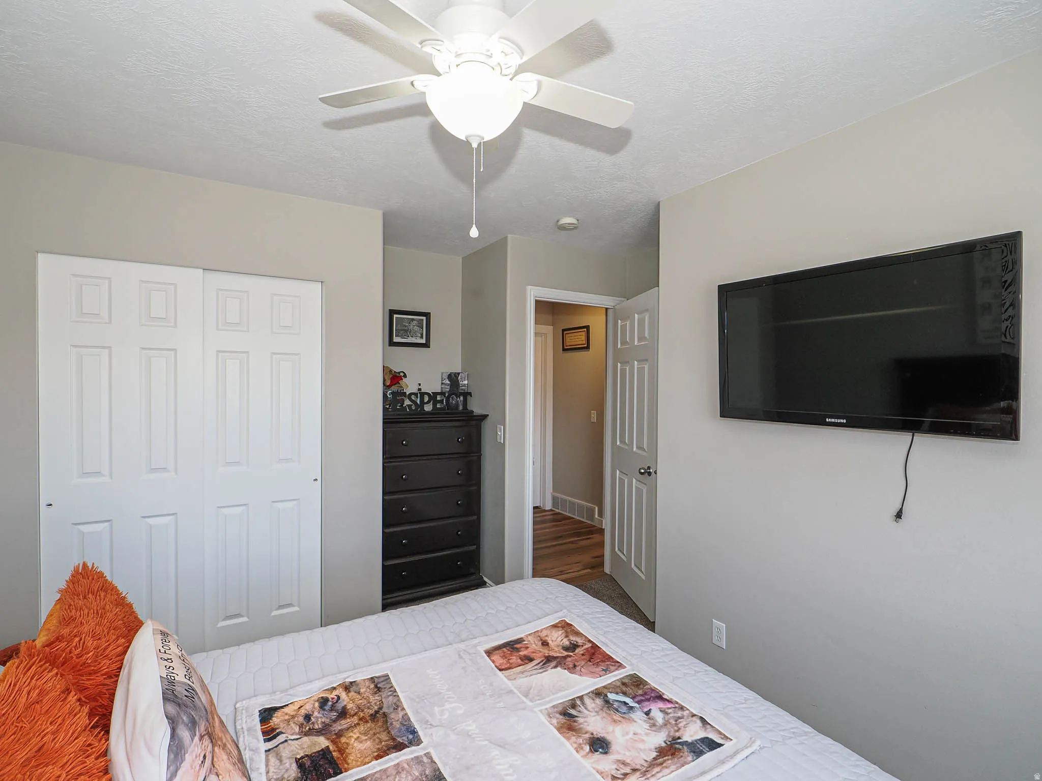 Bedroom with a ceiling fan, a textured ceiling, and a closet