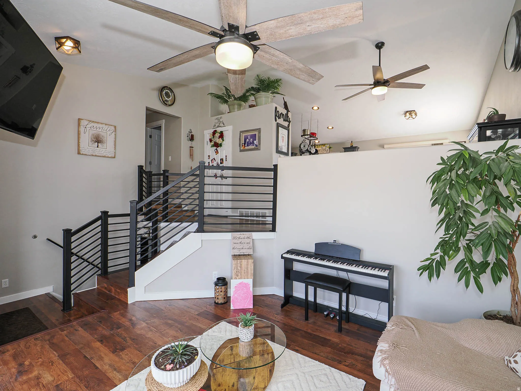 Living room with lofted ceiling, dark wood-style floors, and ceiling fan