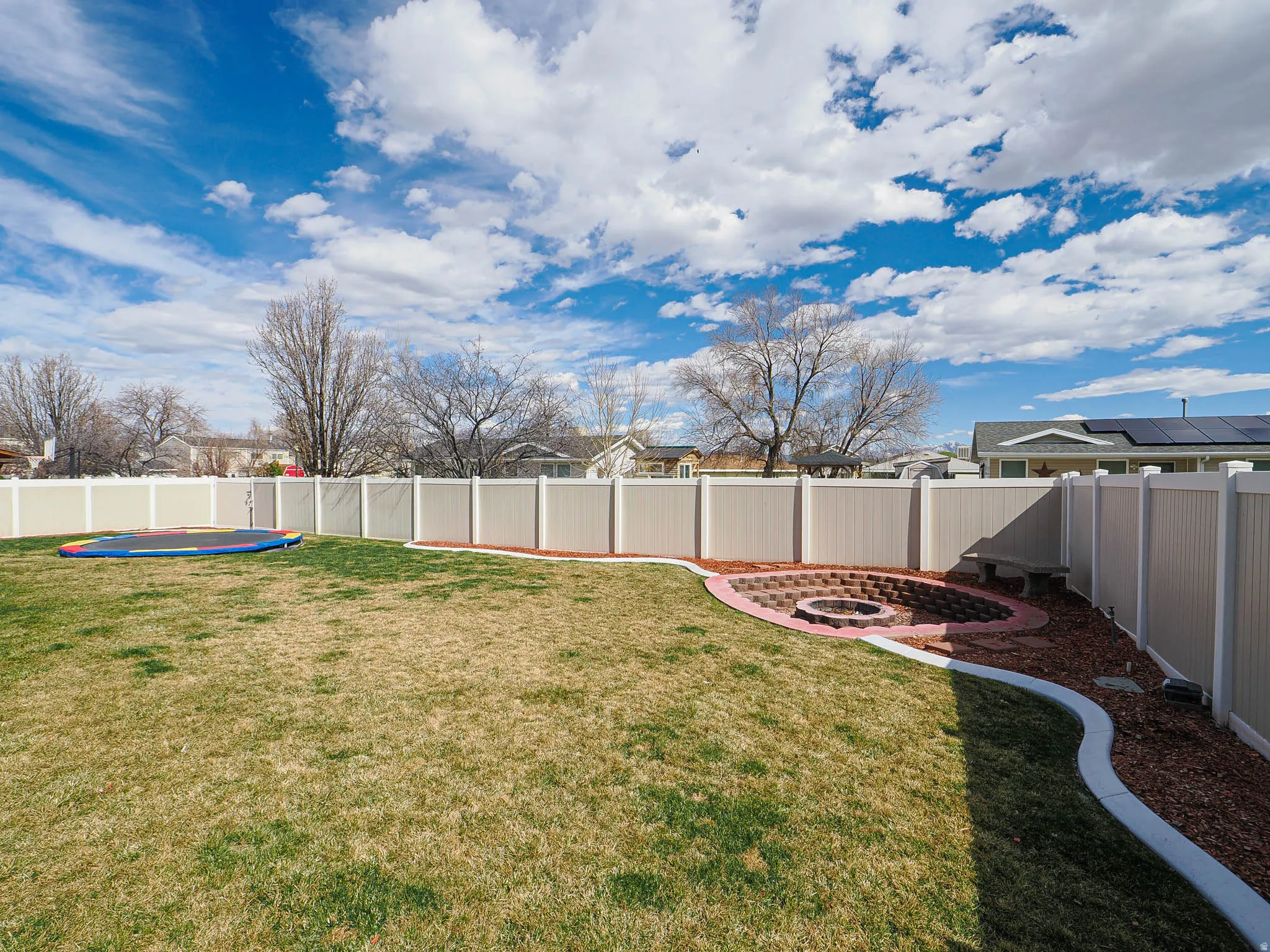 Fenced backyard with a patio and an outdoor fire pit