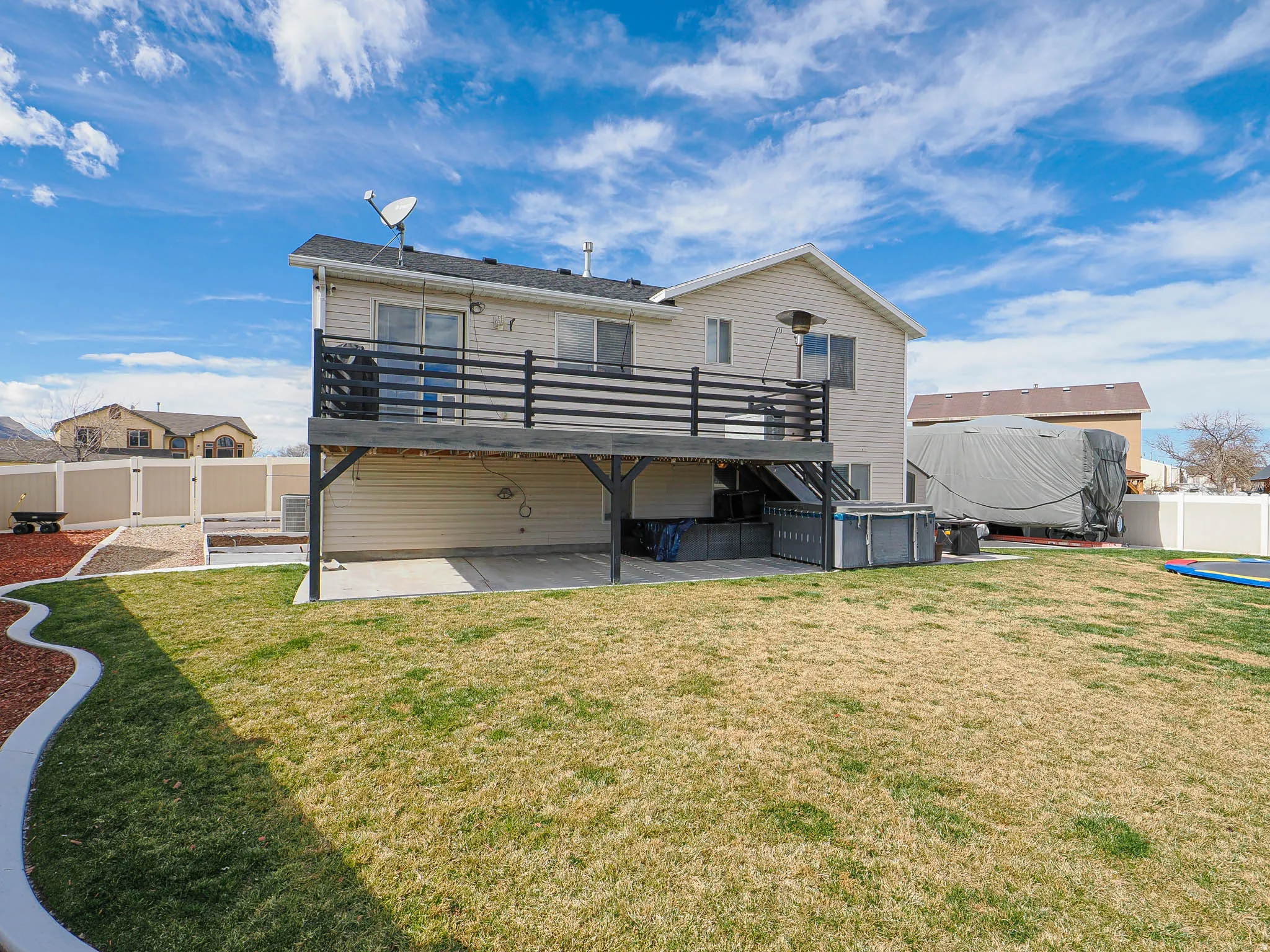 Rear view of house with a fenced backyard, a deck, and a patio area