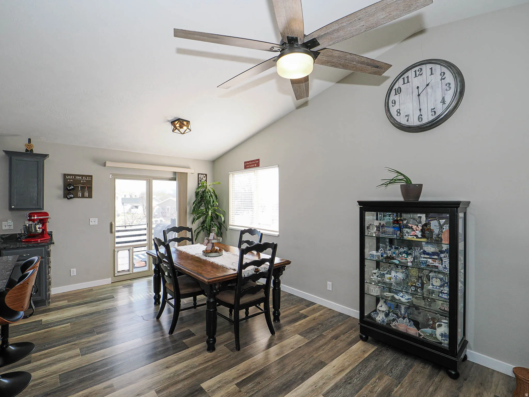 Dining space featuring vaulted ceiling, dark wood-style floors, and ceiling fan