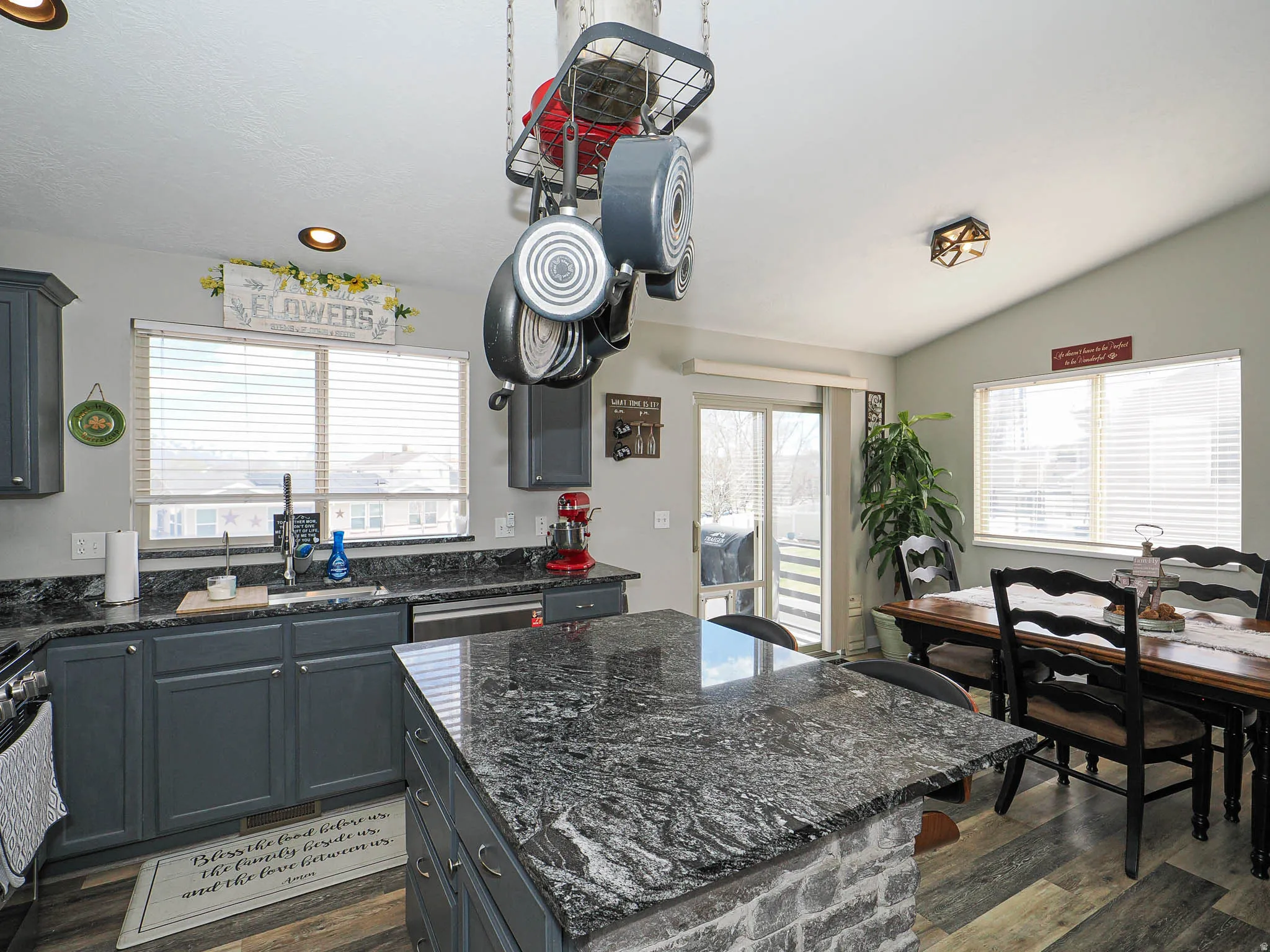 Kitchen with a kitchen island, dark stone countertops, dark wood finished floors, gray cabinets, and recessed lighting