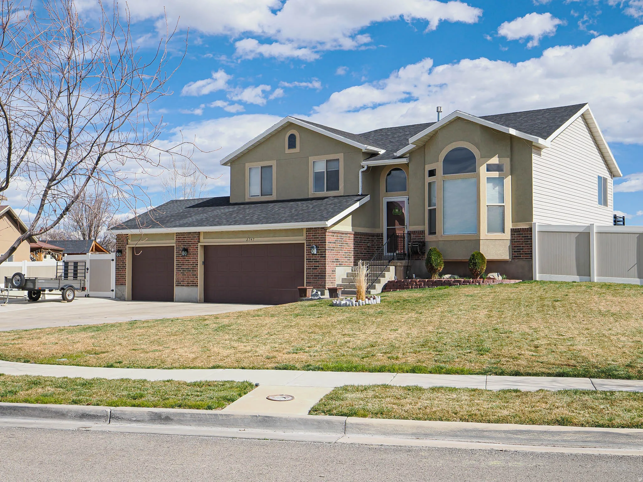 View of front of home with concrete driveway, stucco siding, brick siding, roof with shingles, and an attached garage