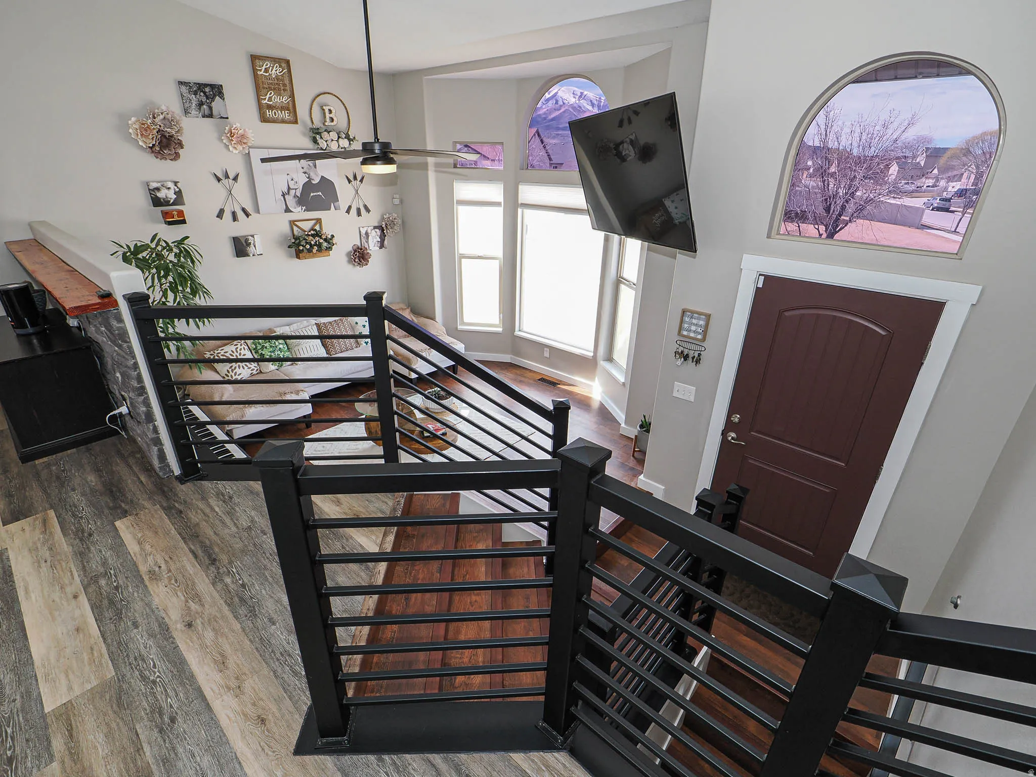 Foyer entrance with wood finished floors, ceiling fan, and vaulted ceiling