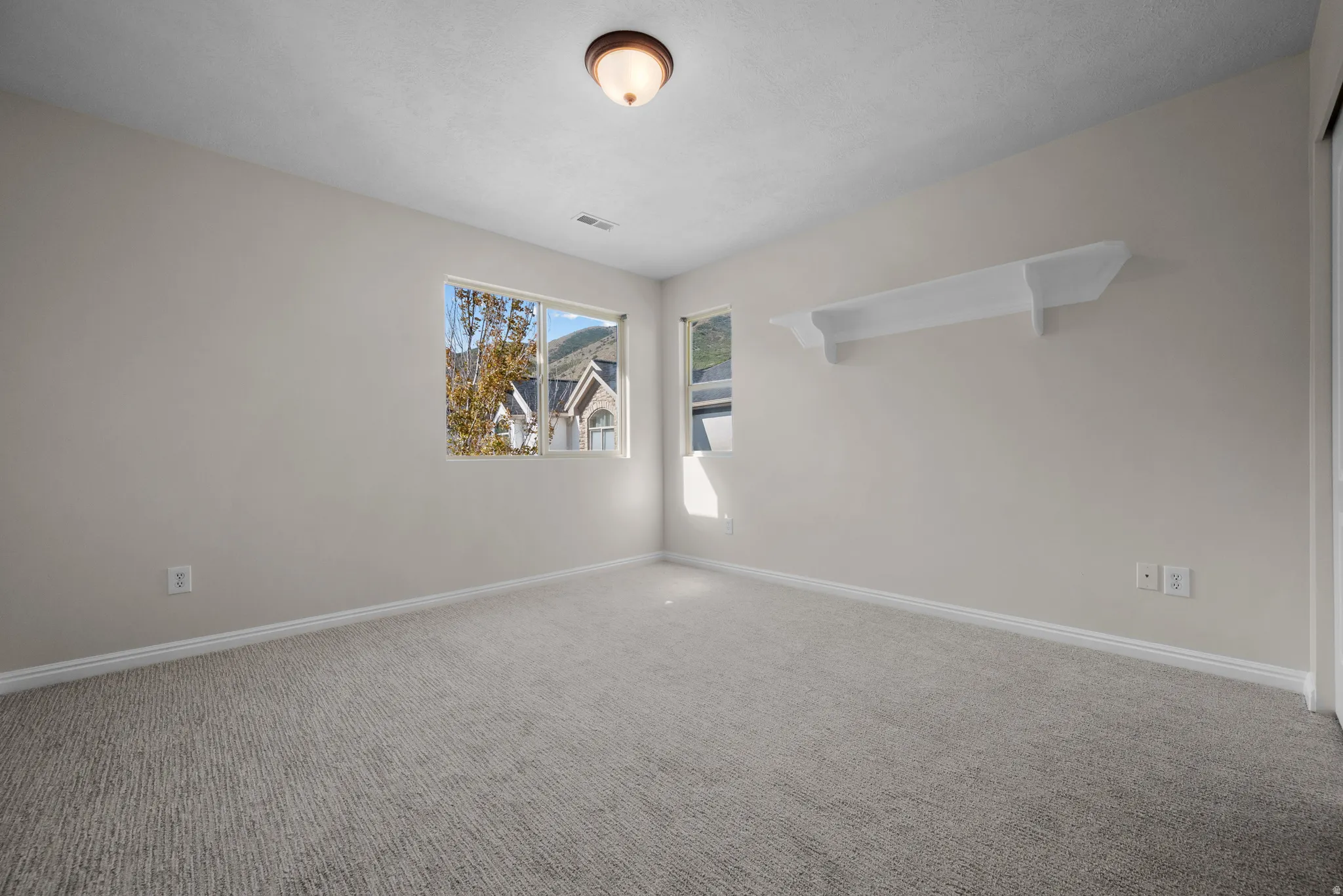 Empty room featuring carpet and baseboards