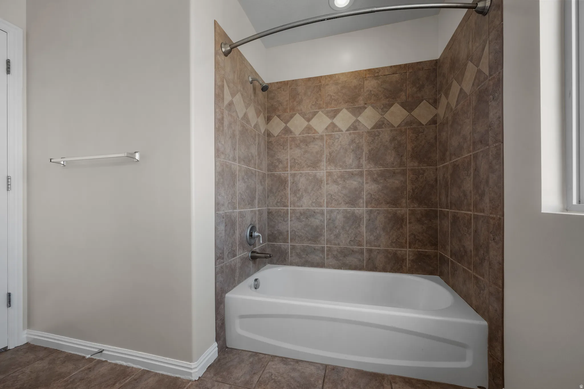 Bathroom featuring washtub / shower combination and baseboards