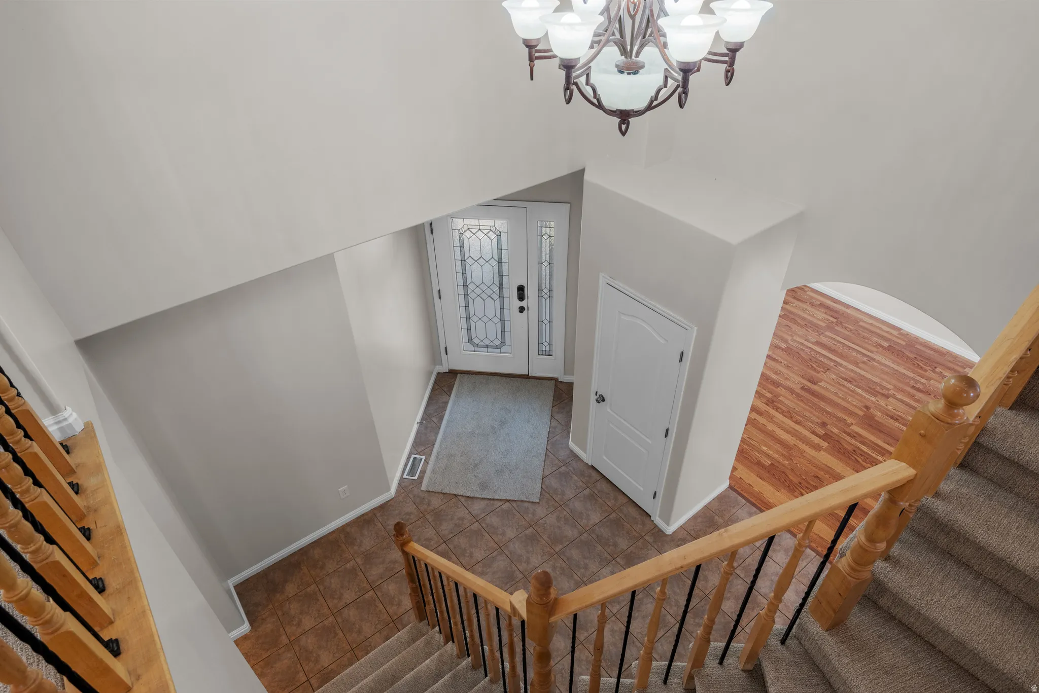 Stairs featuring suspended lighting and tile patterned floors