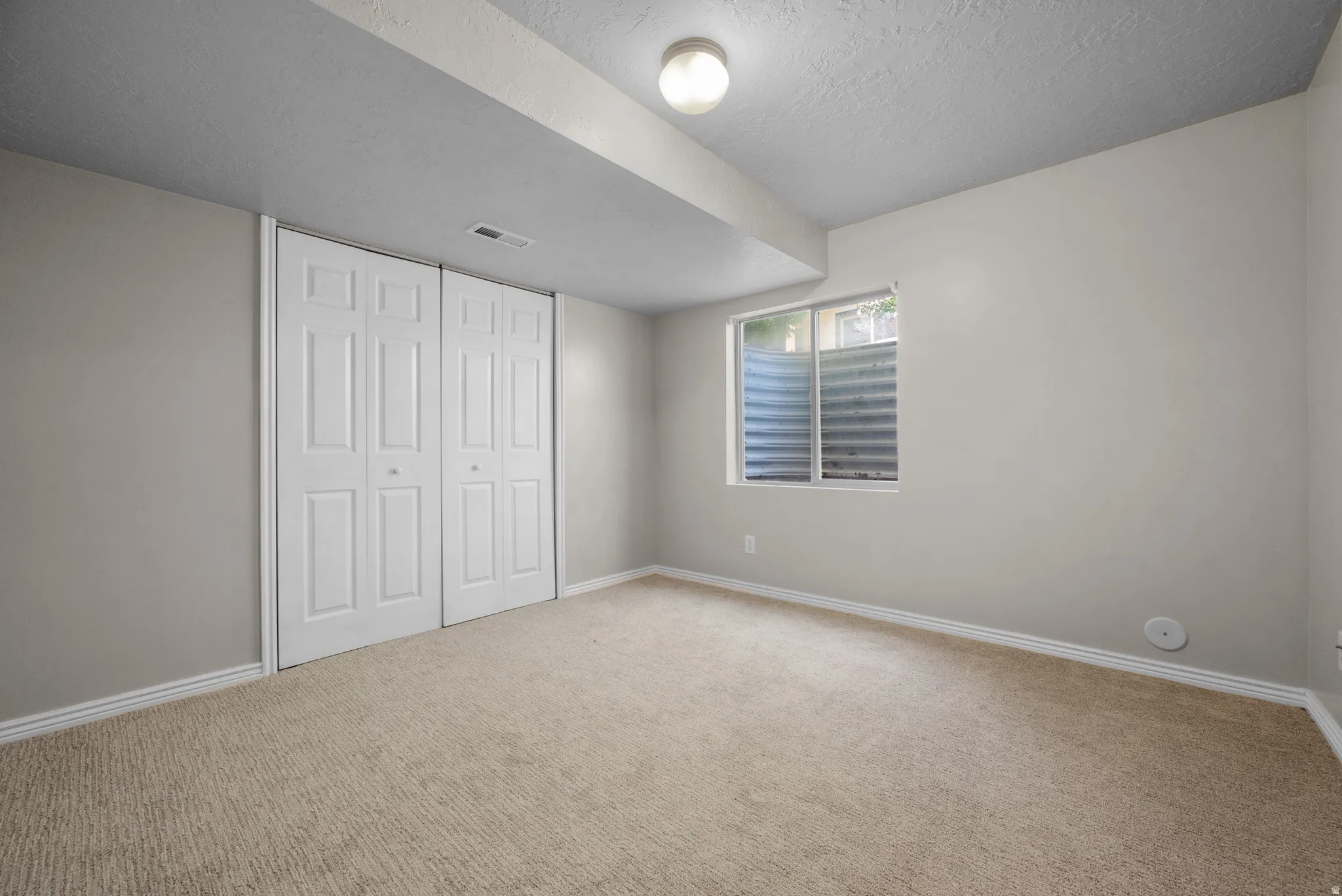 Unfurnished bedroom with a closet, carpet flooring, and a textured ceiling