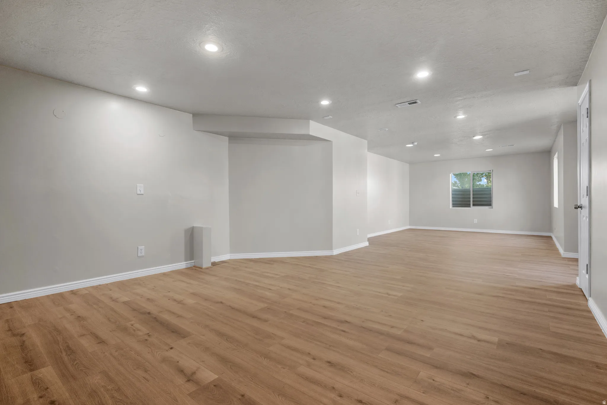 Spare room with recessed lighting, light wood-style floors, and a textured ceiling