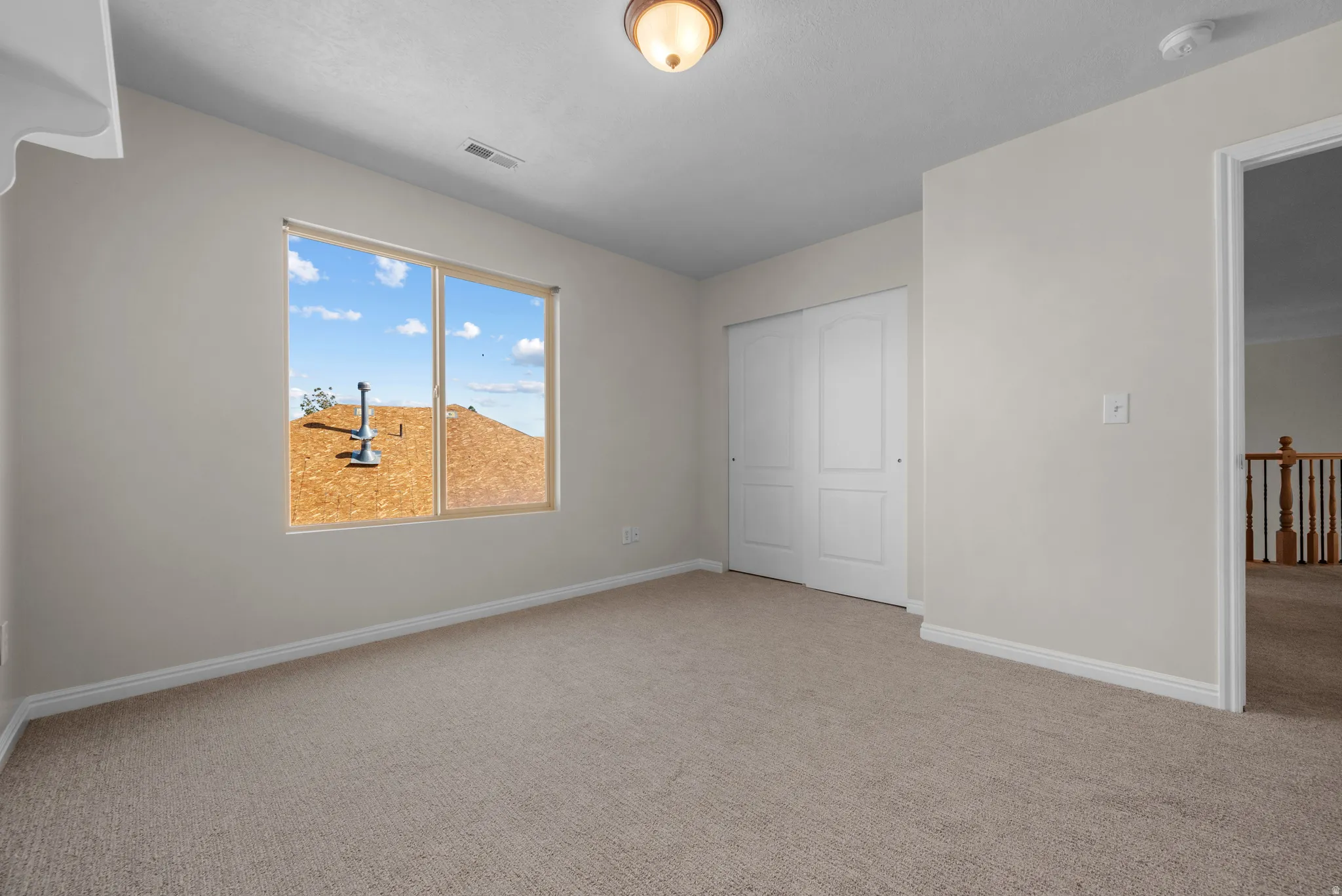 Unfurnished bedroom with light carpet and a closet
