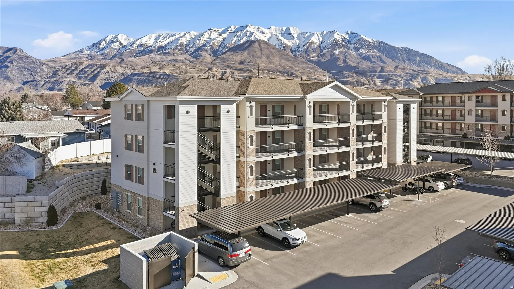 View of apartment building / complex featuring uncovered parking and a mountain view