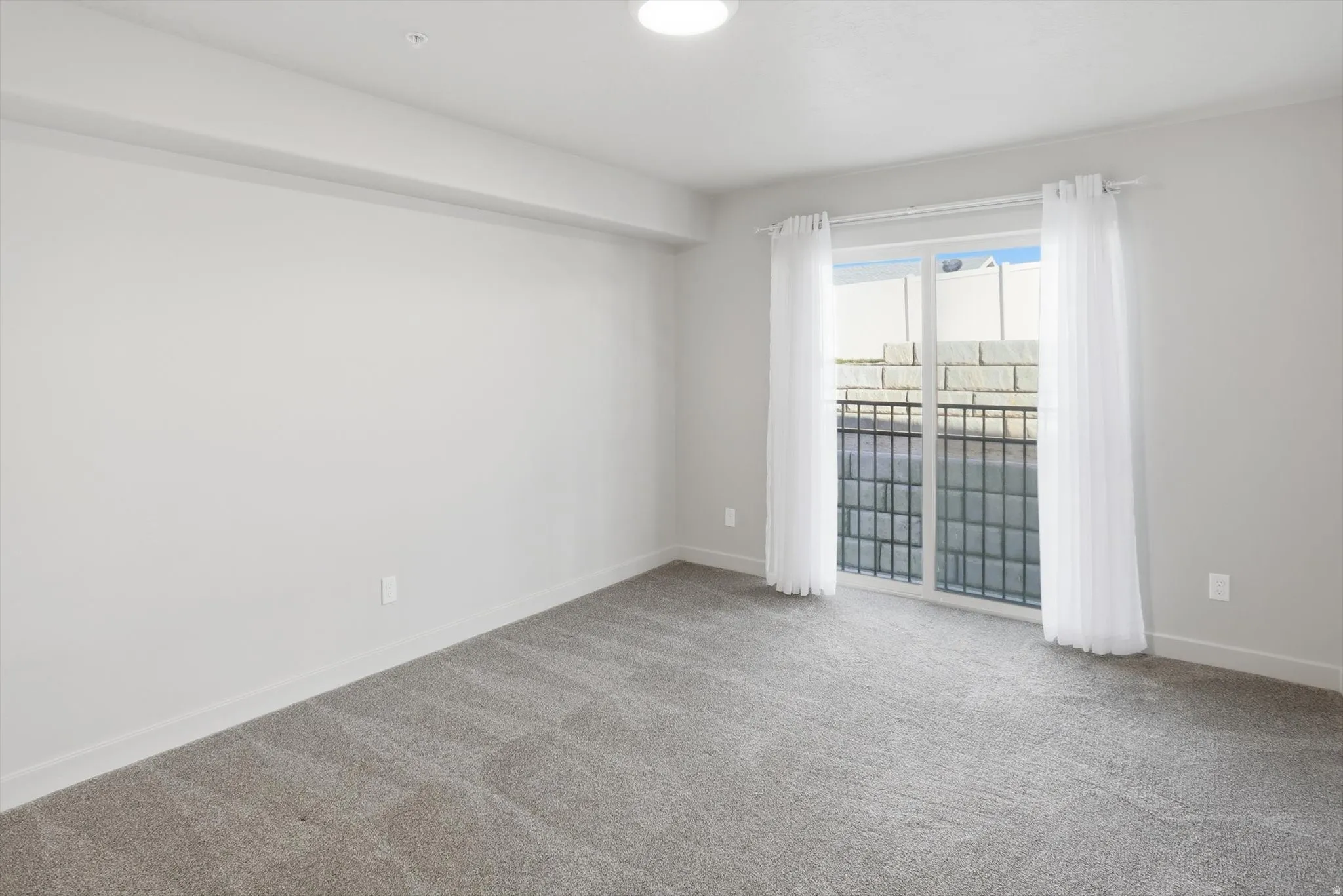 Spare room with baseboards and light carpet