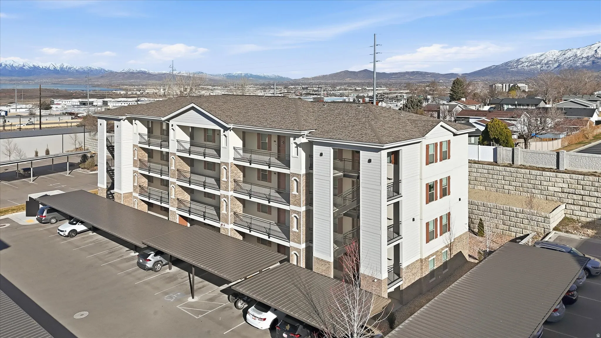 View of apartment building / complex featuring a mountain view and uncovered parking