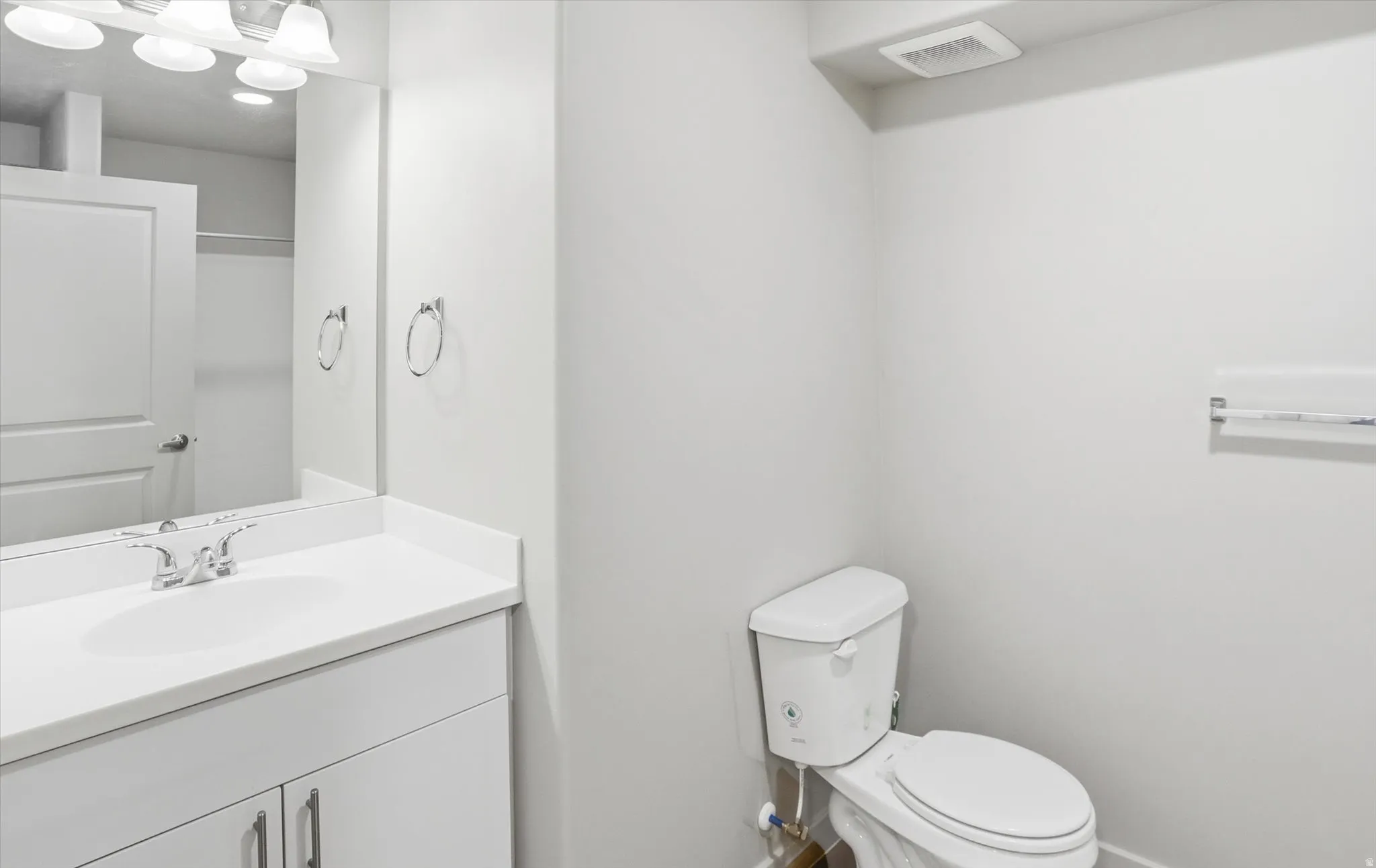 Half bathroom with vanity and toilet