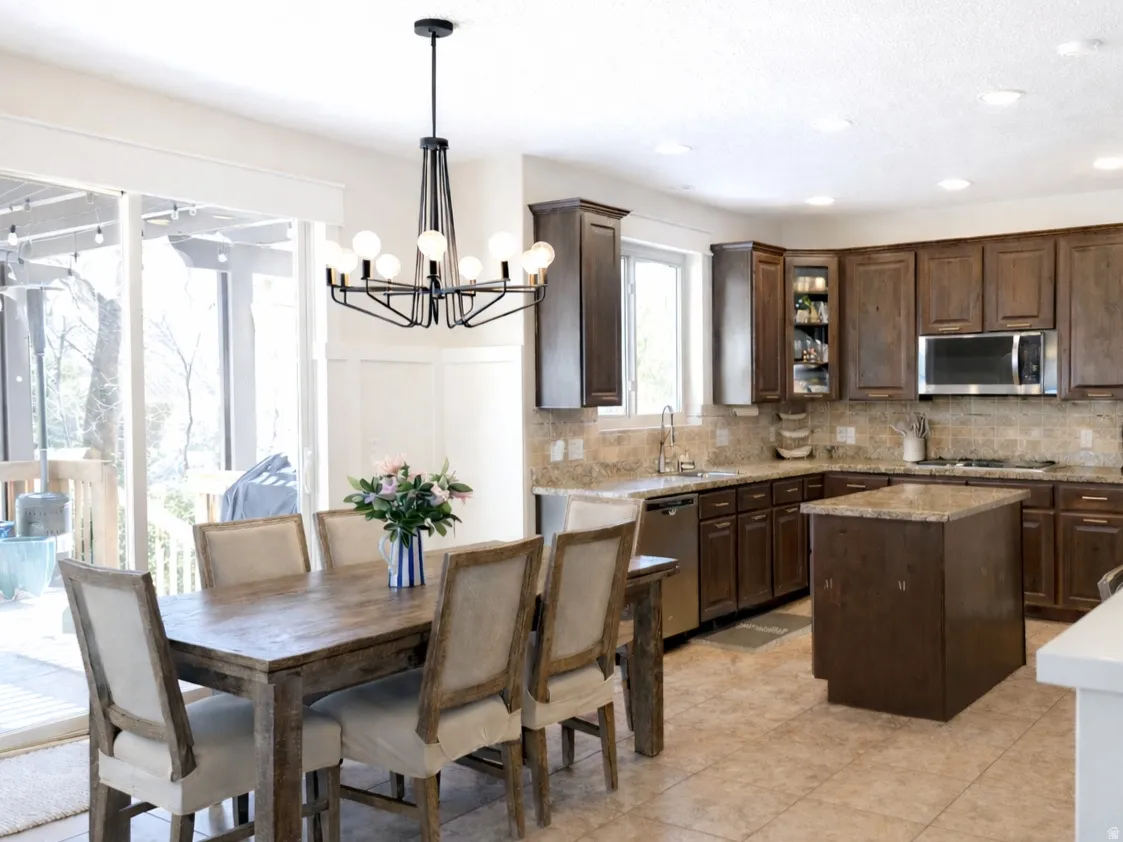 Kitchen with dark wood finish cabinetry, a center island, stainless steel appliances, and granite countertops