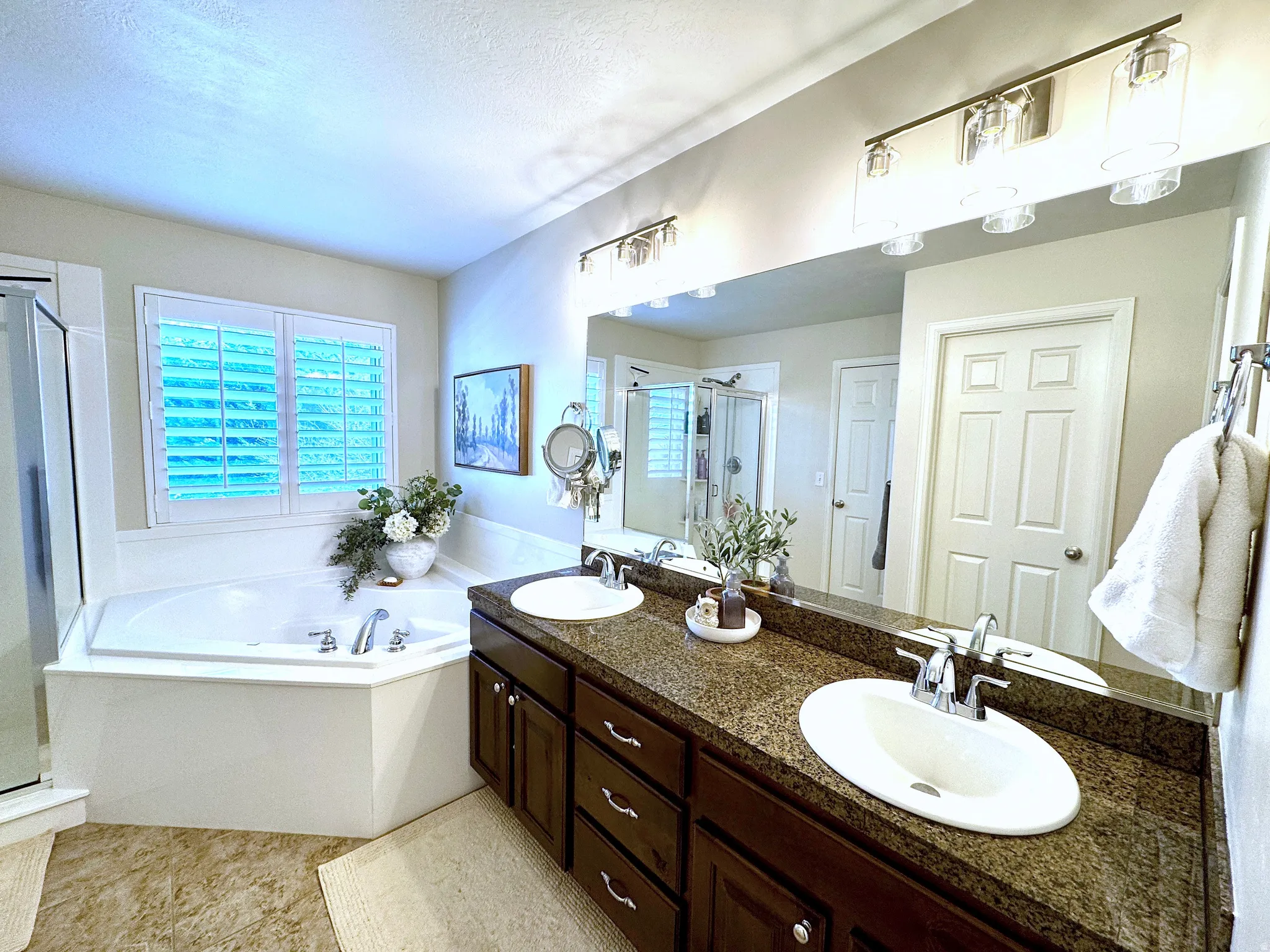 Master bath featuring double vanity, separate shower, soaker tub, and tile flooring
