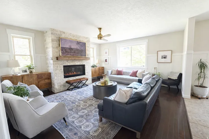 Living area featuring a wainscoted wall, a fireplace, hardwood flooring, and a textured ceiling