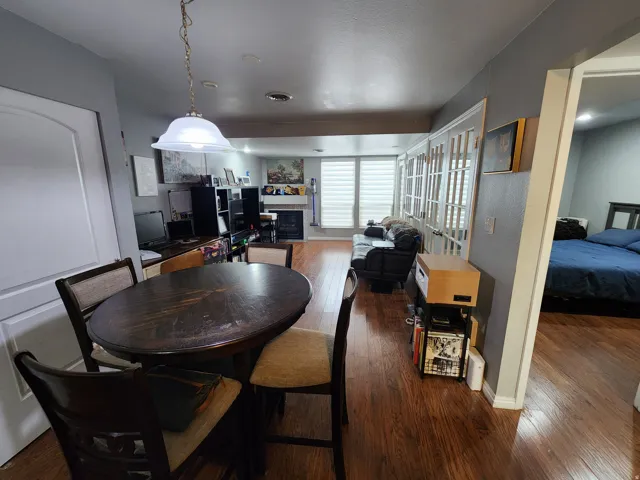 Dining room with a covered fireplace and dark wood-style floors