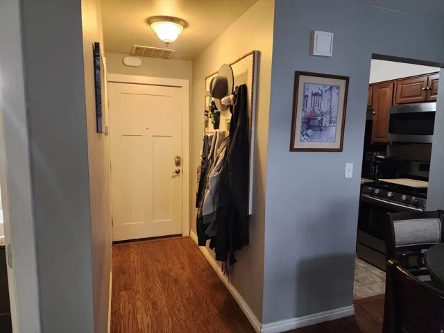 Doorway with wood finished floors and baseboards