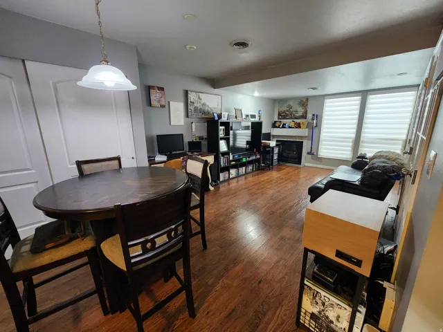 Dining room featuring dark wood finished floors and a fireplace
