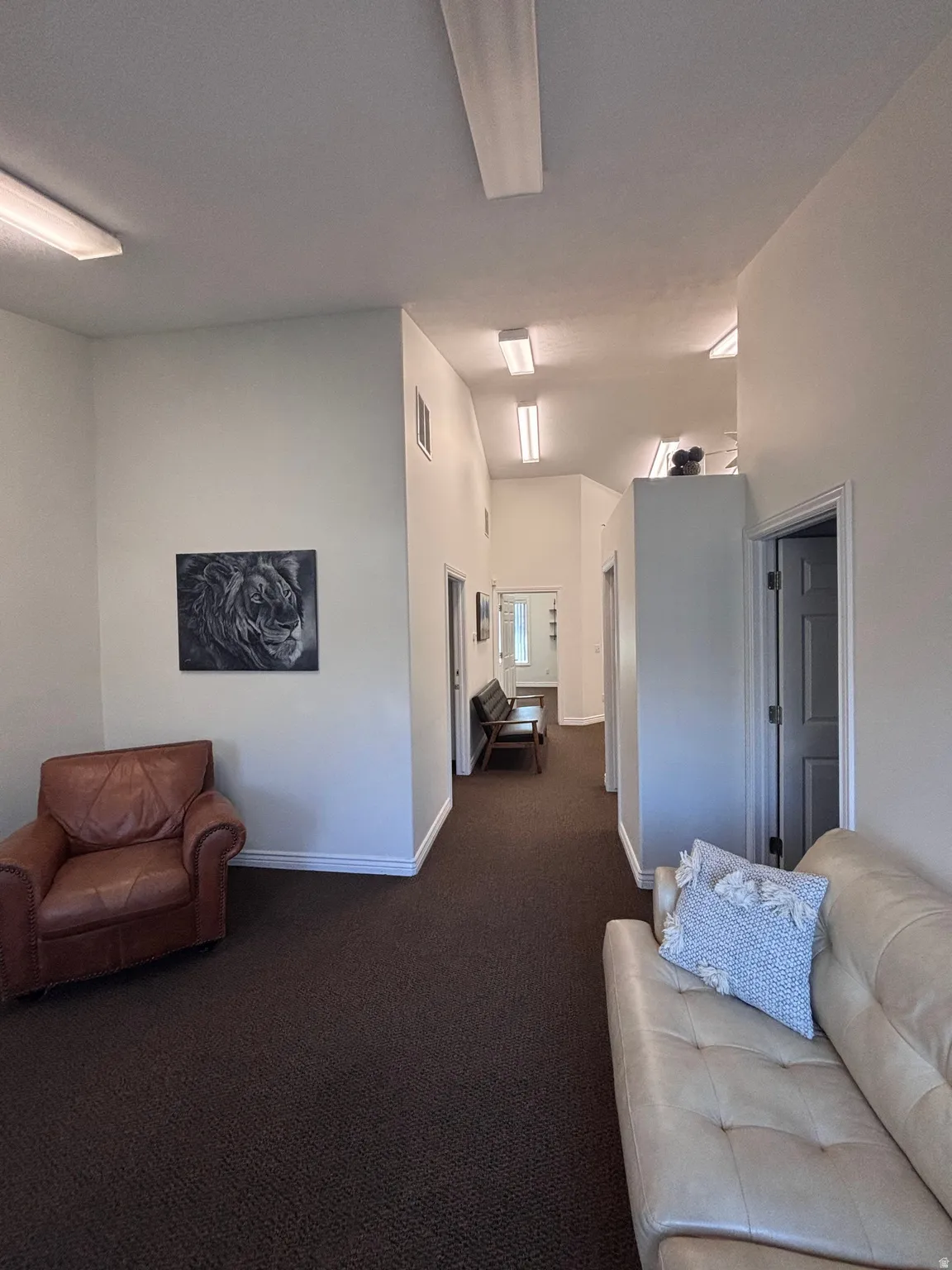 Living room with dark colored carpet and a high ceiling