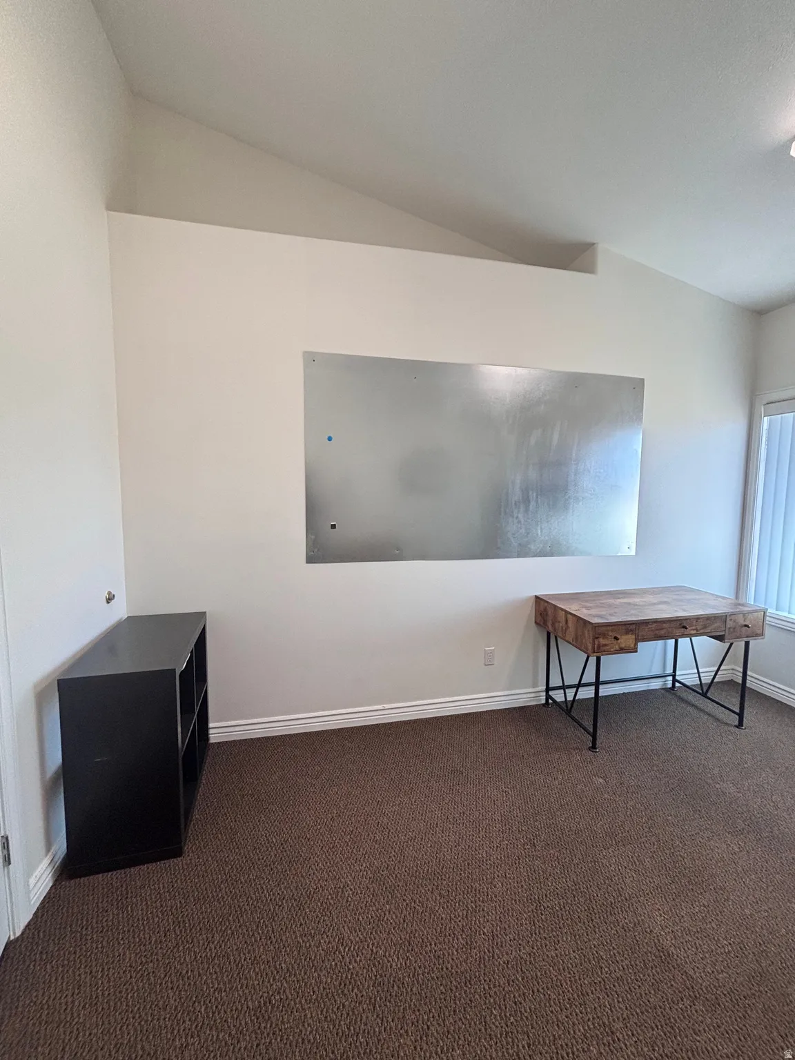 Interior space with vaulted ceiling and dark carpet