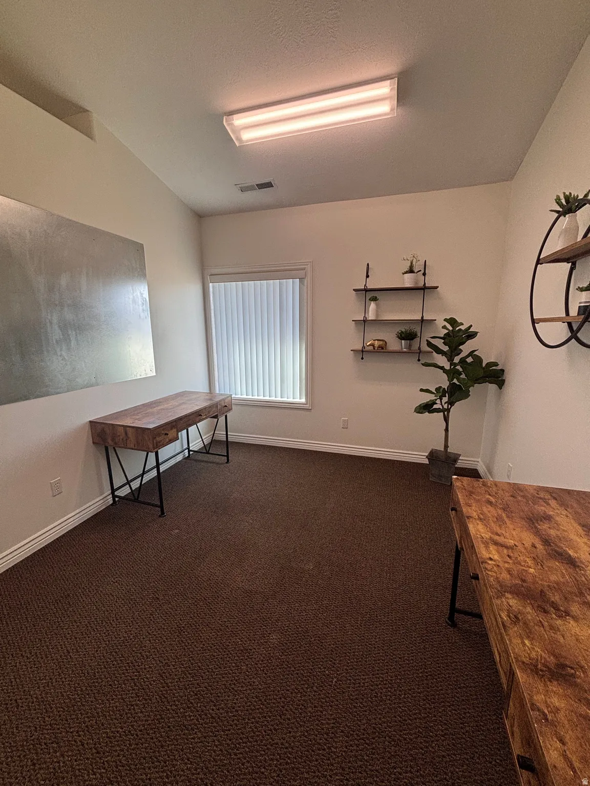 Office with dark carpet and a textured ceiling
