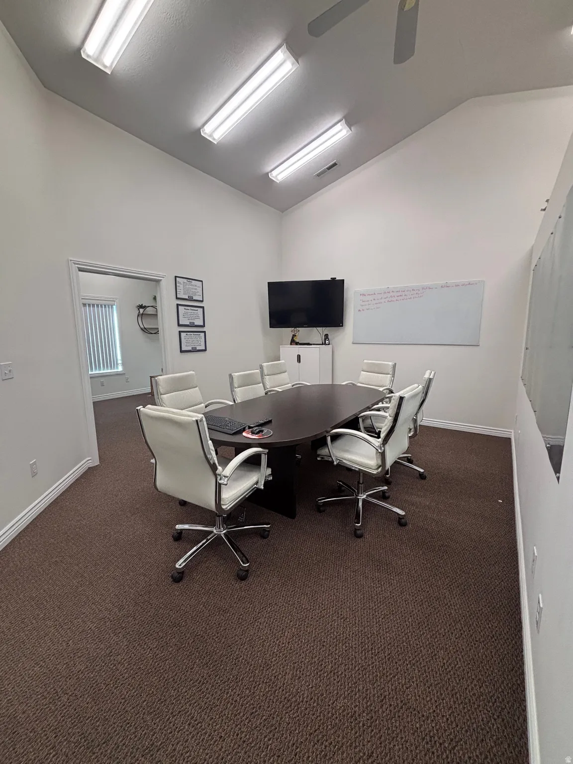 Office area featuring vaulted ceiling and a ceiling fan