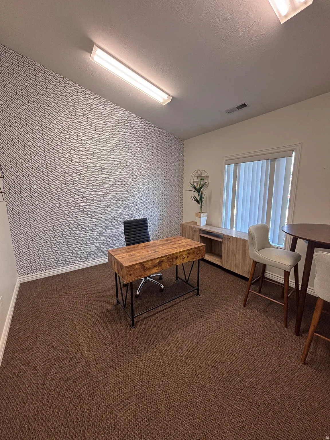 Office area featuring wallpapered walls