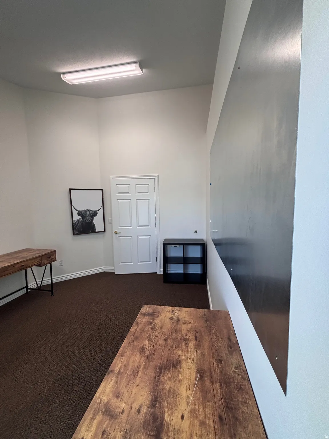 Misc room with dark carpet and baseboards