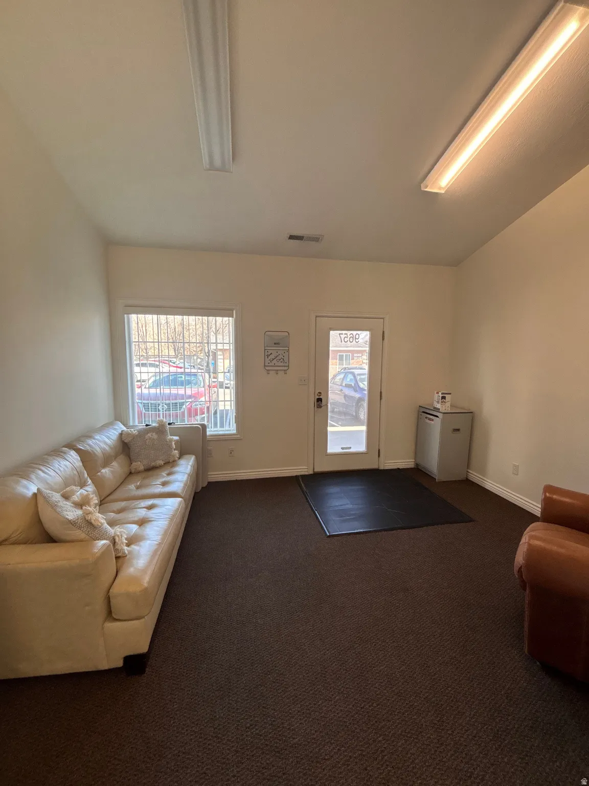 Living area featuring dark carpet and baseboards